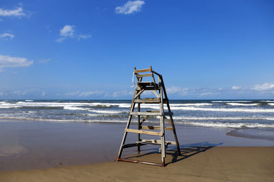 Lifeguard hut on beach against sky