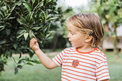 Girl standing by plants against blurred background