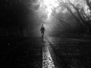 Rear view of woman walking on road