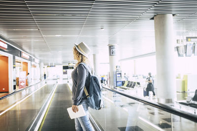 Side view of woman wearing hat at airport