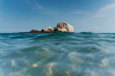 Scenic view of rocks in sea against sky