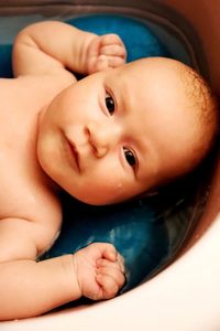 Close-up portrait of cute baby taking bath at home