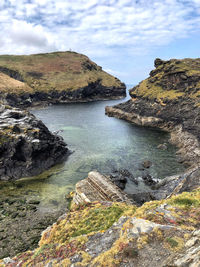 Scenic view of rocks on shore against sky