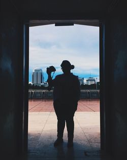 Rear view of silhouette man standing against sky