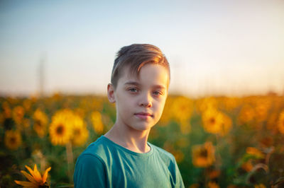 Portrait of boy on field against sky