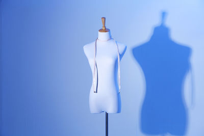 Tape measure on mannequin against wall