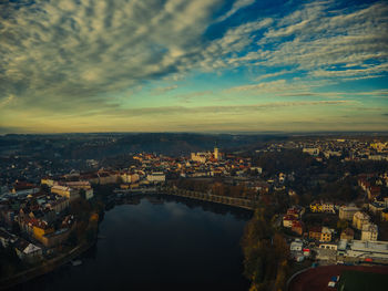 Aerial view of river flowing in town during sunset