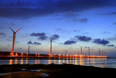 Silhouette of wind turbine against sky during sunset