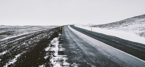 Snow covered road against sky