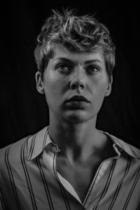 Close-up portrait of young man against black background