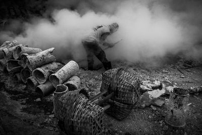 Man wearing gas mask working in volcanic smoke outdoors