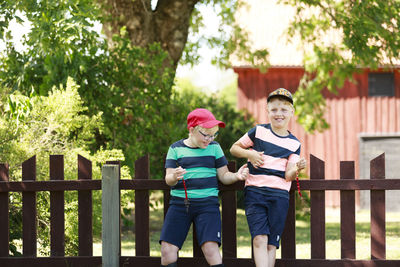 Smiling boys holding wild strawberries