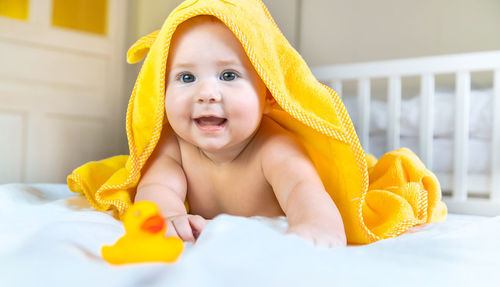 Cute baby girl with towel on head at home