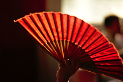 Close-up of hand holding paper hand fan