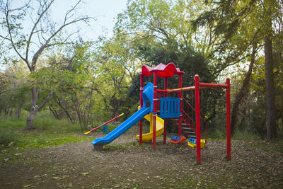 People in playground against trees in park