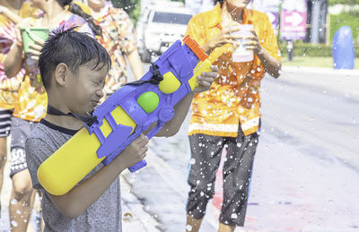 Boy playing with squirt gun outdoors