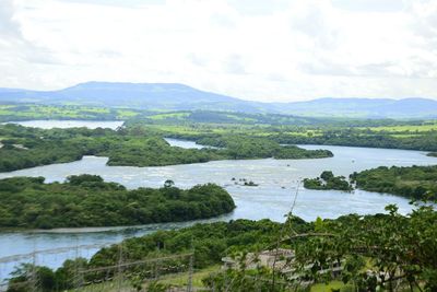 Scenic view of river and mountains against sky