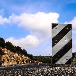 Road sign against sky