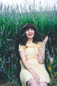 Portrait of a smiling young woman sitting on field