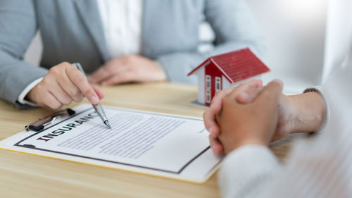 Insurance concept the selling broker reading the contract of purchasing house to his customer.