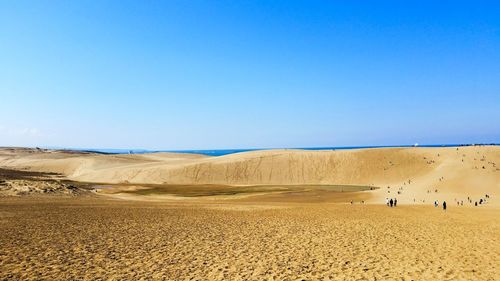 Scenic view of desert against clear blue sky