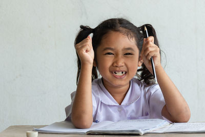 Portrait of cute girl studying at classroom