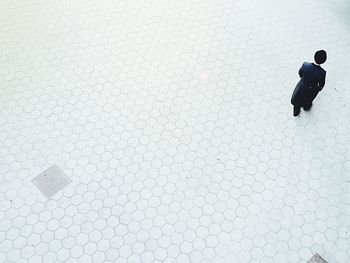 High angle view of man walking on footpath in city