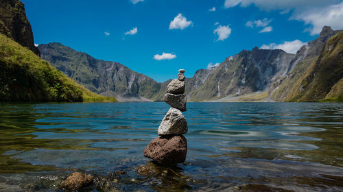 Stack of rocks by mountain against sky
