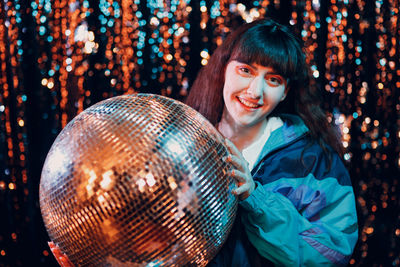 Side view of woman holding illuminated light bulb