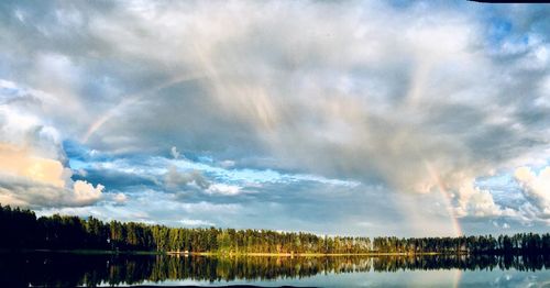 Scenic view of rainbow over lake against sky