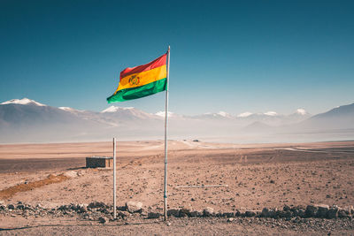 Bolivian flag fluttering on landscape against clear sky
