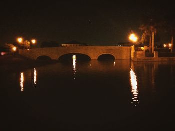 Illuminated bridge against sky at night