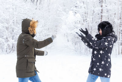 Friends standing on snow covered tree