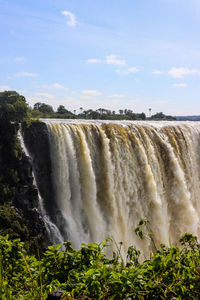 Scenic view of waterfall against sky