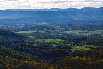 Scenic view of field and mountains against sky