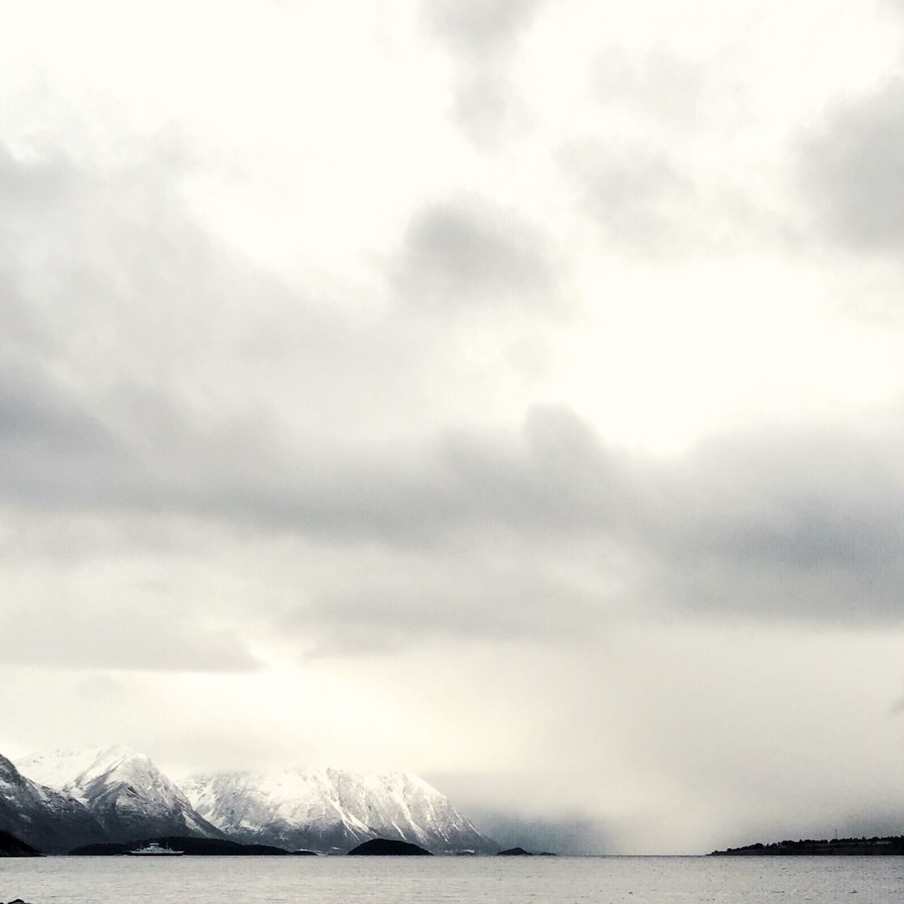 water, waterfront, scenics, sky, sea, tranquil scene, beauty in nature, tranquility, mountain, cloud - sky, nature, cloudy, weather, mountain range, idyllic, cloud, outdoors, day, no people, overcast