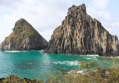 Panoramic shot of rocks in sea against sky