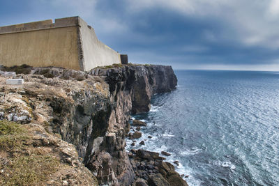 Rock formations by sea against sky