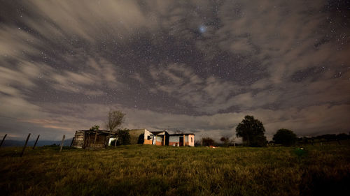 House on field against sky at night