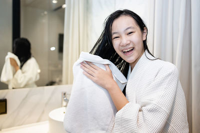 Portrait of a smiling young woman holding camera