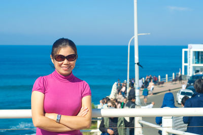 Portrait of woman standing against sea