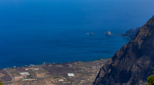 High angle view of sea and rocks against sky