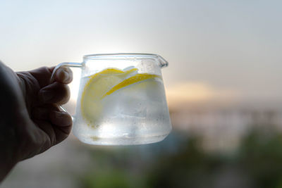 Close-up of hand holding glass of water