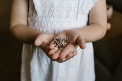 Midsection of flower girl holding wedding rings