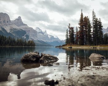 Scenic view of lake by mountains against sky