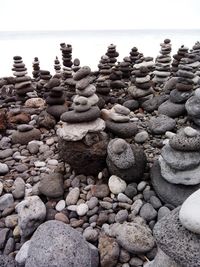 Pebbles on beach against clear sky