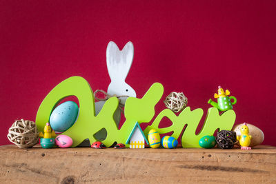 Multi colored toys on table against wall