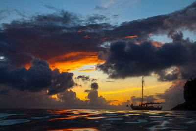 Scenic view of sea against dramatic sky during sunset