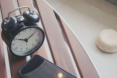 Close-up of alarm clock and mobile phone on the table