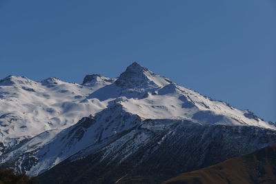 Scenic view of snowcapped mountains against clear blue sky